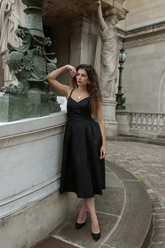 a lady in a black spaghetti strap gathered-waist dress